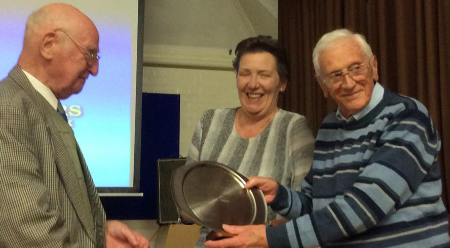 Ron presents the plate to Ken